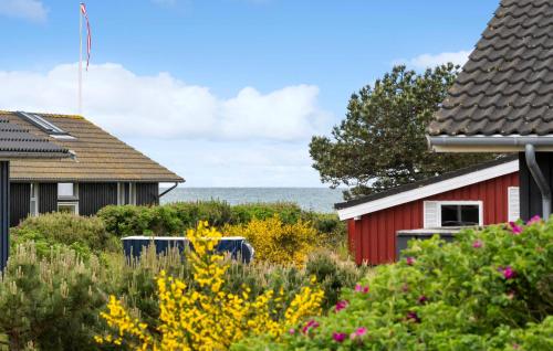 una casa roja con el océano en el fondo en 3 Bedroom Awesome Home In Slagelse, en Slagelse