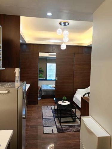 a kitchen with a refrigerator and a table in a room at 1 bedroom Cozy Escape in Manila
