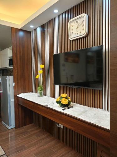 a counter with a clock and flowers on a wall at 1 bedroom Cozy Escape in Manila