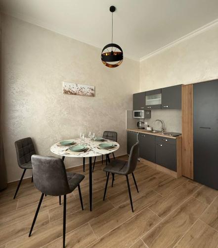 a dining room with a table and chairs and a kitchen at Family Apartments Zemlinski in Payerbach