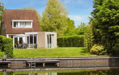 a house with a garden and a lake at Nice Home In Vlagtwedde in Vlagtwedde