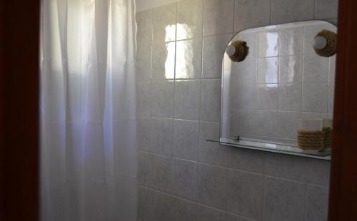 a bathroom with a shower curtain and a mirror at Floralia in Karterados