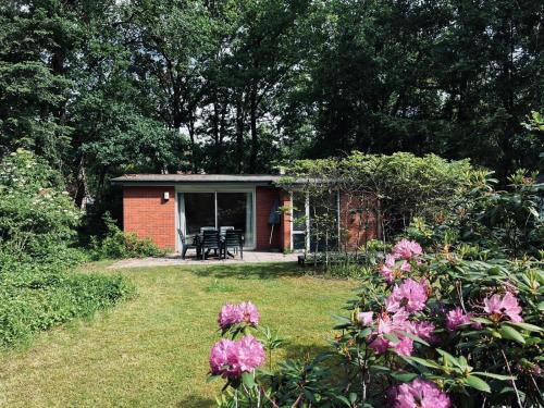 a small shed with a table and chairs in a yard at Green Escape Hellendoorn rust & natuur in Hellendoorn