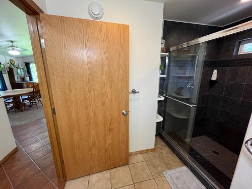 a bathroom with a shower and a wooden door at Cozy Palmer Retreat with Steam Sauna and Playground in Palmer