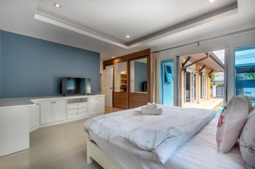 a bedroom with a large white bed and a television at 3 Bedroom Pool Villa 5kms from Patong in Ban Kathu