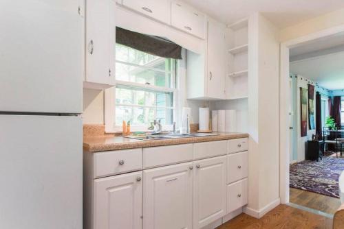 a white kitchen with a sink and a window at Private Green Cottage near downtown in Asheville