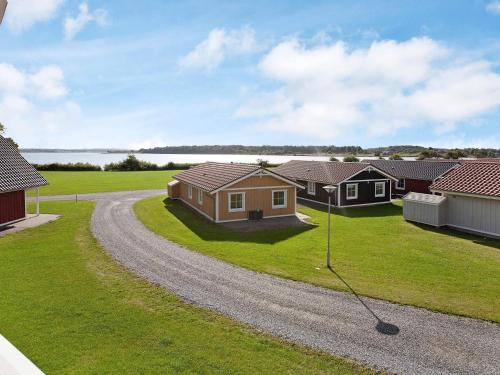 a house on a gravel road in front of houses at 6 person holiday home on a holiday park in Gråsten in Gråsten