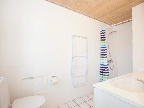 a white bathroom with a toilet and a sink at Type 10- Ho Holiday Centre holiday home in Blåvand