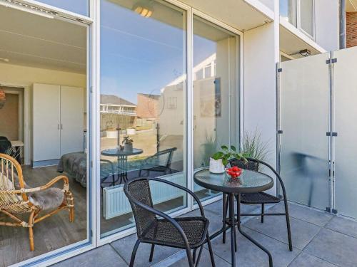 a patio with a table and chairs on a balcony at 2 person holiday home in Ringkøbing in Ringkøbing