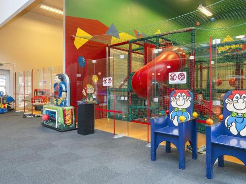 a play room with two chairs and a playground at Holiday home with sauna, whirlpool- Type1 in Blåvand