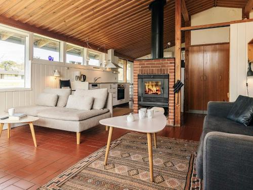 a living room with a couch and a fireplace at Premium room on a holiday park in Gilleleje in Gilleleje