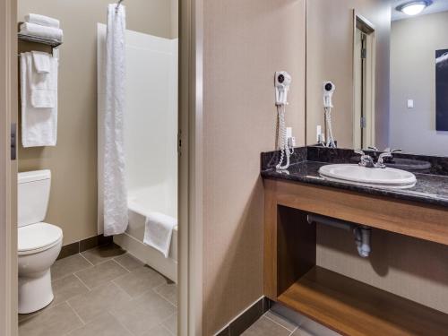 a bathroom with a toilet, sink, and shower at Heritage Inn Hotel & Convention Centre - Pincher Creek in Pincher Creek