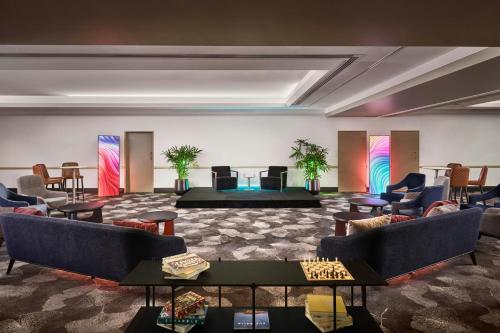 a large room with couches and tables and chairs at Sheraton Grand Sydney Hyde Park in Sydney