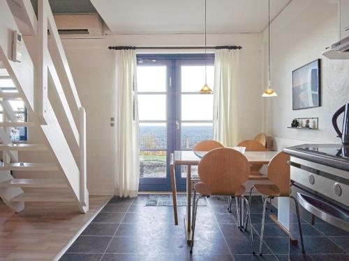 a dining room with a table and chairs and a window at 5 person holiday home on a holiday park in Gudhjem in Gudhjem