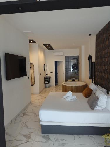 a bedroom with a large white bed and a television at Reina Victoria La Plaza in Alicante