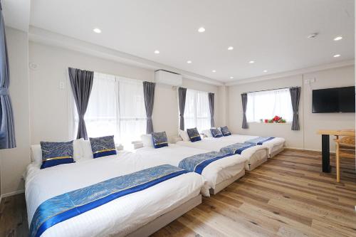 a row of beds in a room with windows at Unite Stay URAYASU 101 8 minutes by car or 15 minutes by bus to Disneyland in Tokyo