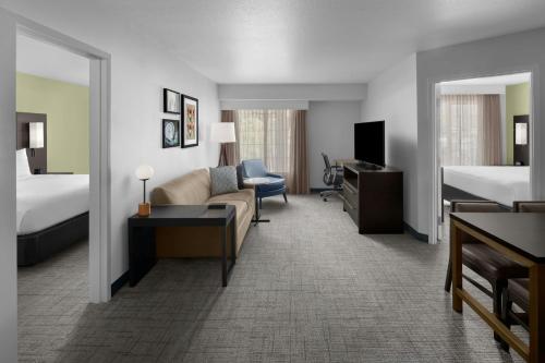 a hotel room with a couch and a bed at Residence Inn Salt Lake City Sandy in Sandy