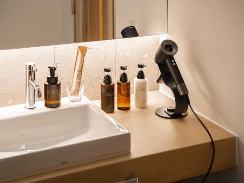 a bathroom counter with a sink and a blow dryer at Dansetsu Sapporo - Opening in Apr 2025 in Sapporo