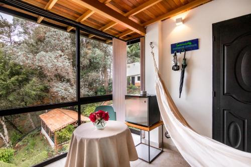 a room with a table and a large window at Serendipity Hospedaje Boutique in Guatapé