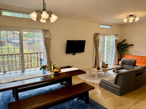 a living room with a couch and a table at 23年9月新築のレイクビューアメリカンハウス 和美インターから3分ゴルフ場近郊 in Karuizawa