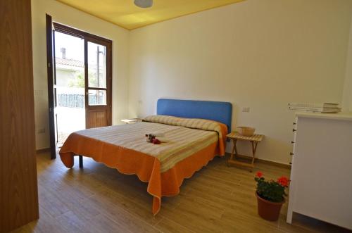 1 dormitorio con 1 cama con cabecero azul en Casa Vacanza Via Sulcis, en Tortolì