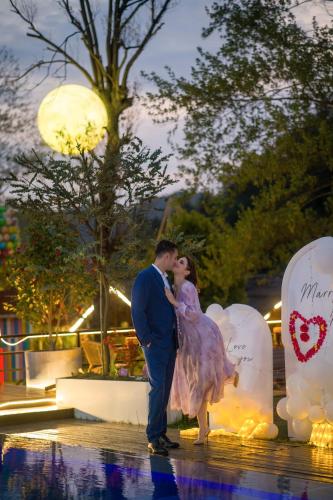 a bride and groom are kissing in front of balloons at Pandora Vista Retreat in Zhangjiajie