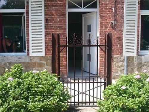 a white door on a brick house with bushes at Charmante maison avec jardin, 3 chambres, proche Val Joly - Idéal familles et randonneurs - FR-1-510-157 in Liessies