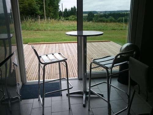 a table and two chairs in front of a window at Charmante maison avec jardin, 3 chambres, proche Val Joly - Idéal familles et randonneurs - FR-1-510-157 in Liessies