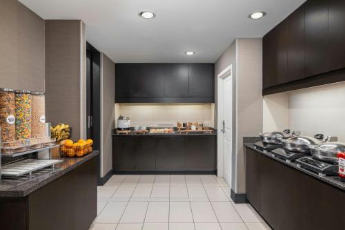 a large kitchen with black cabinets and a counter at Residence Inn by Marriott Champaign in Champaign