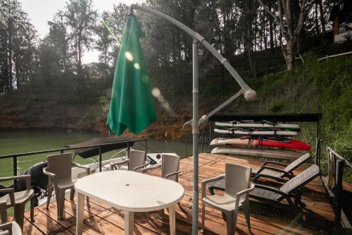 a deck with chairs and a table and an umbrella at Serendipity Hospedaje Boutique in Guatapé