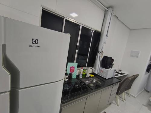 a kitchen with a refrigerator and a counter top at Studio CG 4, Campo Grande RJ in Estação Inhoaíba