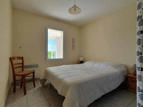 ein Schlafzimmer mit einem Bett und einem Stuhl und einem Fenster in der Unterkunft Maison calme pour 4 personnes avec jardin - FR-1-476-111 in Grues
