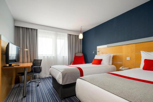 a hotel room with two beds and a desk at Holiday Inn Express London - Epsom Downs by IHG in Epsom