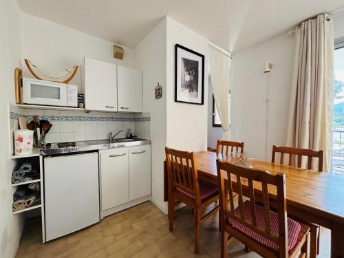 - une cuisine et une salle à manger avec une table et un four micro-ondes dans l'établissement Appartement 4 pers au port d'Argelès avec terrasse, parking - FR-1-309-512, à Argelès-sur-Mer