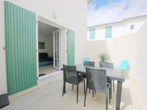 une salle à manger avec une table et des chaises dans l'établissement Appartement fonctionnel intra-muros avec cour et garage sécurisé - FR-1-835-1, à Saint-Martin-de-Ré