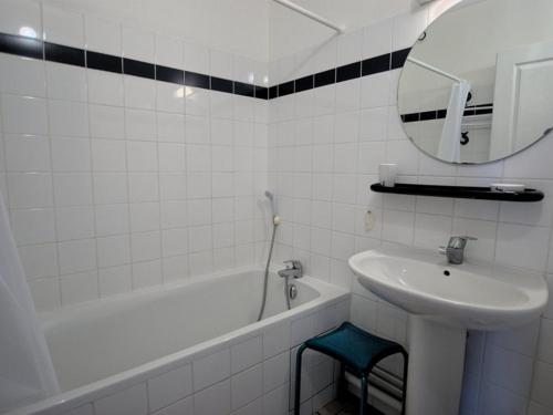 une salle de bain avec un lavabo, une baignoire et un miroir dans l'établissement Appartement fonctionnel intra-muros avec cour et garage sécurisé - FR-1-835-1, à Saint-Martin-de-Ré