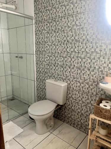 a bathroom with a toilet and a shower at Casa Donna Flor 2 Quartos Completa Centrinho com Garagem Coberta in Catas Altas