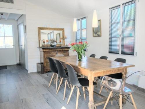 une salle à manger avec une table et des chaises en bois dans l'établissement Maison charmante avec WiFi près des plages et pistes cyclables - FR-1-835-9, au Bois-Plage-en-Ré