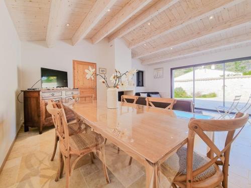 une salle à manger avec une table et des chaises en bois dans l'établissement Maison 110m² Sud-Ouest avec Terrasse, Patio, et Parking pour 6 Personnes - FR-1-835-12, au Bois-Plage-en-Ré
