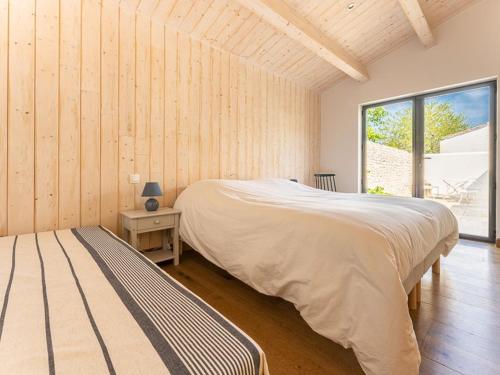une chambre avec un grand lit et une fenêtre dans l'établissement Maison 110m² Sud-Ouest avec Terrasse, Patio, et Parking pour 6 Personnes - FR-1-835-12, au Bois-Plage-en-Ré