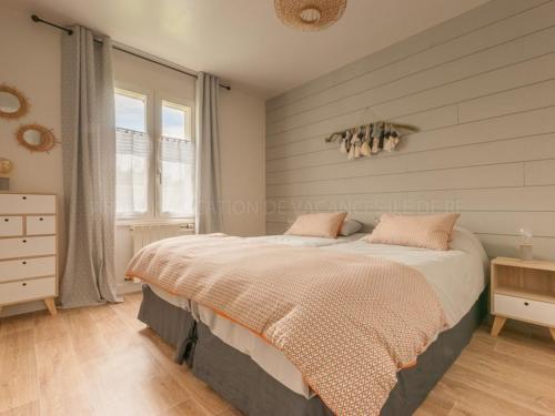 ein Schlafzimmer mit einem großen Bett in einem Zimmer in der Unterkunft Maison spacieuse pour 8 au Bois-Plage-en-Ré avec jardin - FR-1-835-13 in Le Bois-Plage-en-Ré