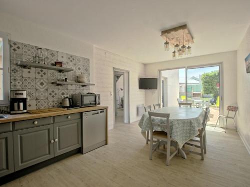 une cuisine avec une table et une salle à manger dans l'établissement Maison pour 6 avec jardin sud et parking à La Flotte - FR-1-835-21, à La Flotte