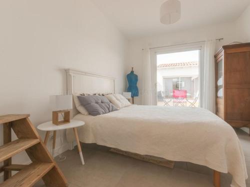 une chambre blanche avec un lit et une fenêtre dans l'établissement Maison spacieuse à Le Bois-Plage-en-Ré avec terrasse et stationnement - FR-1-835-5, au Bois-Plage-en-Ré