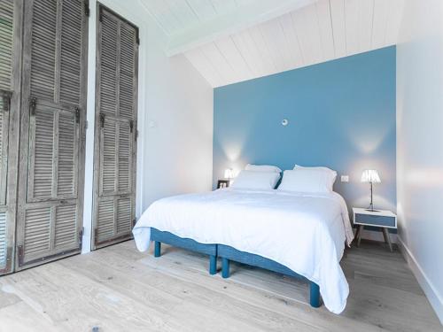 - une chambre blanche avec un grand lit blanc et des murs bleus dans l'établissement Maison de plain-pied pour 8 pers. à La Flotte avec terrasse et parking - FR-1-835-15, à La Flotte