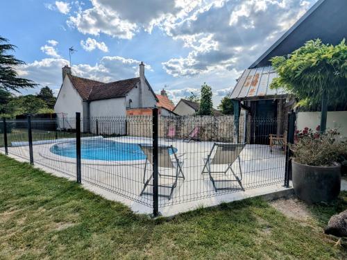 une clôture avec deux chaises autour d'une piscine dans l'établissement Évasion au bord du Cher, près des châteaux - FR-1-591-738, à Chabris