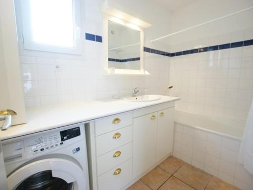 une salle de bain blanche avec une machine à laver et un lavabo dans l'établissement Appartement Intramuros avec Cour à Saint-Martin-de-Ré - FR-1-835-14, à Saint-Martin-de-Ré