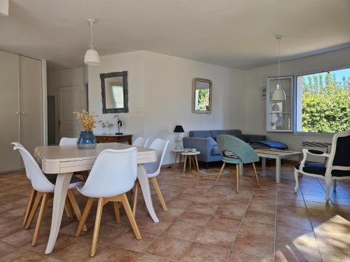 un salon avec une table et des chaises dans l'établissement Maisonnette confort 7 pers, accès plage direct - FR-1-476-237, à La Faute-sur-Mer