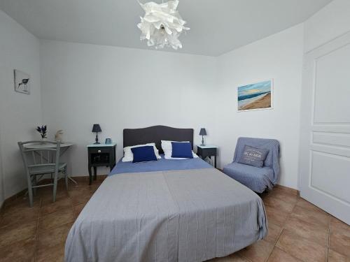 - une chambre avec un lit, une chaise et un lustre dans l'établissement Maisonnette confort 7 pers, accès plage direct - FR-1-476-237, à La Faute-sur-Mer