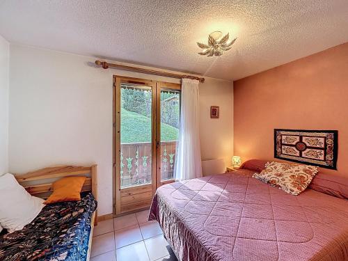 une chambre avec deux lits et une fenêtre dans l'établissement Appartement proche village, accès ski bus, vue Mont Blanc - FR-1-560-163, à Combloux