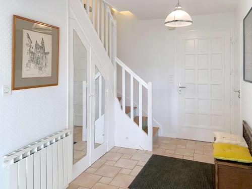 un couloir avec une porte blanche et un escalier dans l'établissement Villa spacieuse 6 pièces - 9 pers - À 50m de la plage - FR-1-361-567, à Jullouville
